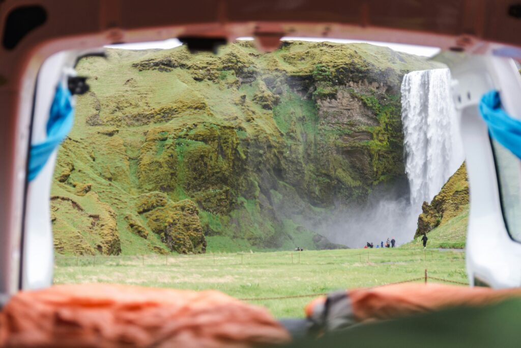 View of Skogafoss waterfall from a campervan in a campsite in Iceland